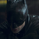 Robert Pattinson in full costume for The Batman, drenched in rain.
